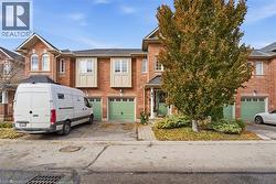 View of front of home with brick siding, driveway, a garage, and roof with shingles - 