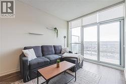 Living area with floor to ceiling windows, a textured ceiling, baseboards, and wood finished floors - 