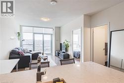 Kitchen featuring expansive windows, a textured ceiling, open floor plan, wood finished floors, and light stone countertops - 