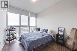Bedroom with expansive windows, baseboards, and dark wood-type flooring - 