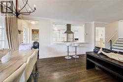 Dining space with dark wood finished floors, stairway, and a chandelier - 