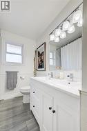 Bathroom with wainscoting, vanity, tile walls, and curtained shower - 