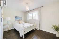Bedroom featuring baseboards and dark wood-type flooring - 