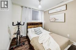 Bedroom with dark wood finished floors and ornamental molding - 