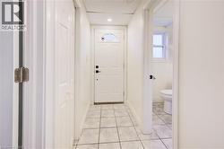 Doorway with tile patterned flooring and baseboards - 
