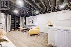 Living room featuring light wood-style flooring and stairway - 