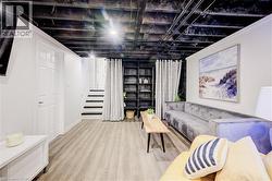 Finished basement featuring stairway and wood finished floors - 