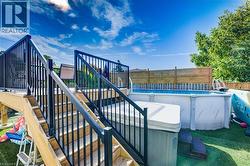 View of swimming pool with a jacuzzi, stairs, and a wooden deck - 