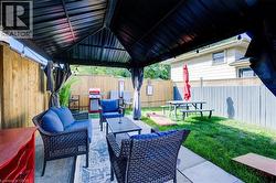 Fenced backyard with a patio area, outdoor lounge area, and area for grilling - 