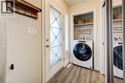 Washroom with washer / clothes dryer and wood finished floors - 