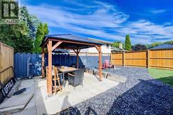 Fenced backyard featuring a gazebo, outdoor dining area, and a patio - 