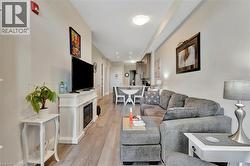 Living area featuring light wood finished floors and a glass covered fireplace - 
