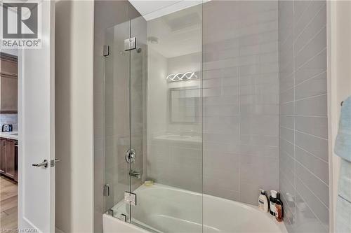 Full bathroom featuring enclosed tub / shower combo and wood finished floors - 85B Morrell Street Unit# 117, Brantford, ON - Indoor Photo Showing Bathroom