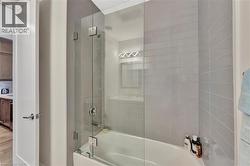 Full bathroom featuring enclosed tub / shower combo and wood finished floors - 