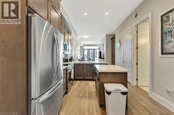 Kitchen with appliances with stainless steel finishes, a peninsula, light countertops, and light wood-style flooring - 