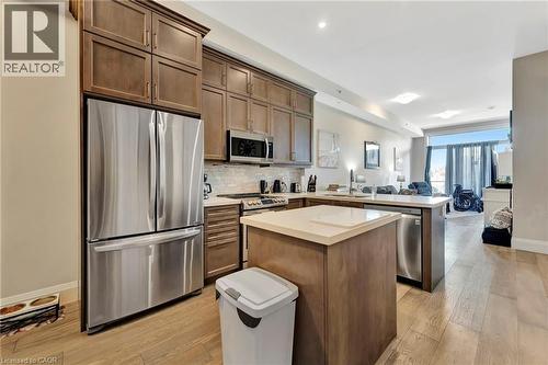 Kitchen featuring stainless steel appliances, open floor plan, light countertops, a peninsula, and tasteful backsplash - 85B Morrell Street Unit# 117, Brantford, ON - Indoor Photo Showing Kitchen With Upgraded Kitchen