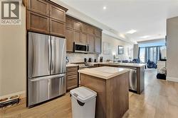 Kitchen featuring stainless steel appliances, open floor plan, light countertops, a peninsula, and tasteful backsplash - 
