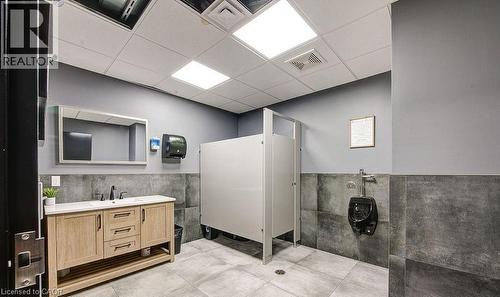 Bathroom featuring a drop ceiling, a wainscoted wall, vanity, and tile walls - 55 Progress Drive E, Aylmer, ON 