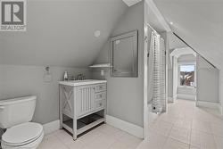 Full bathroom with baseboards, toilet, vanity, a shower with curtain, and lofted ceiling - 