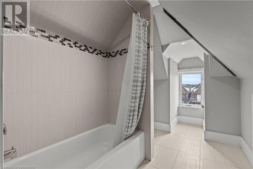 Full bathroom with tile patterned floors, vaulted ceiling, shower / tub combo with curtain, and baseboards - 181 West Avenue N, Hamilton, ON - Indoor Photo Showing Bathroom