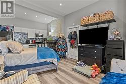 Bedroom with light wood-style flooring, a sink, and recessed lighting - 