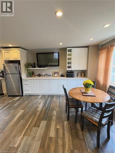 Integrated kitchen and dining area featuring wood-finish flooring, recessed lighting, and a built-in media console with storage cabinetry - 199 Kimberly Drive, Hamilton, ON - Indoor Photo Showing Dining Room