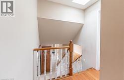 Stairs featuring a skylight and wood finished floors - 