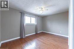 Spare room featuring light wood finished floors, a textured ceiling, and a ceiling fan - 