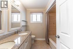 Bathroom featuring plenty of natural light, double vanity, ornamental molding, light tile patterned floors, and shower / bath combo - 