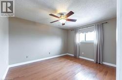 Empty room featuring light wood-style flooring, a textured ceiling, and ceiling fan - 