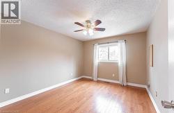 Spare room featuring light wood-style floors, a textured ceiling, and ceiling fan - 