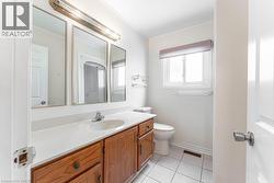 Bathroom featuring vanity, light tile patterned flooring, and ornamental molding - 
