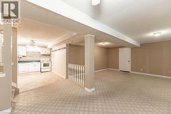 Basement featuring a textured ceiling, a ceiling fan, and light carpet - 
