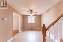 Unfurnished room featuring light tile patterned floors, stairway, a ceiling fan, and a textured ceiling - 