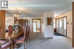 Carpeted dining room with a chandelier and a textured ceiling - 
