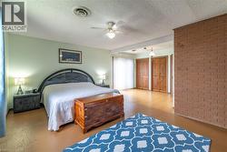 Bedroom featuring a textured ceiling and a ceiling fan - 