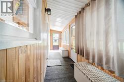 Mudroom featuring lofted ceiling, dark colored carpet, and wood walls - 