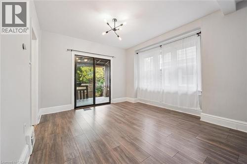 Empty room featuring wood finished floors and a chandelier - 41 Rose Street, Kitchener, ON - Indoor Photo Showing Other Room