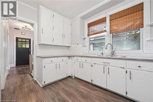 Kitchen featuring open shelves, white cabinetry, tasteful backsplash, dark wood-type flooring, and a textured ceiling - 41 Rose Street, Kitchener, ON - Indoor Photo Showing Kitchen