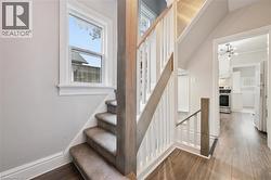 Stairway with wood finished floors and a chandelier - 