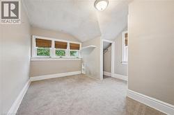 Unfurnished room with a textured ceiling, vaulted ceiling, and light colored carpet - 