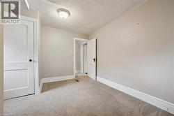 Empty room with a textured ceiling and carpet - 