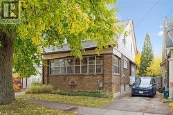 View of home's exterior featuring brick siding and a sunroom - 