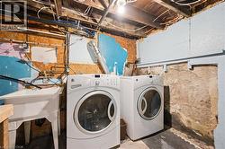 Laundry room with unfinished concrete floors and washer and clothes dryer - 
