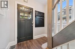 Entryway featuring dark wood-style flooring and baseboards - 