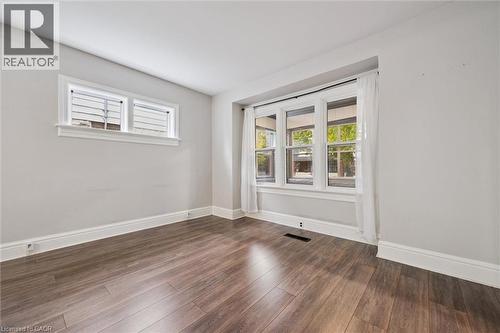 Spare room featuring dark wood-style floors and baseboards - 41 Rose Street, Kitchener, ON - Indoor Photo Showing Other Room