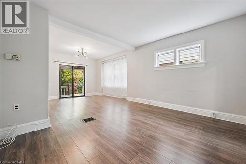 Spare room with a chandelier, wood finished floors, and beamed ceiling - 41 Rose Street, Kitchener, ON - Indoor