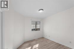 Spare room featuring light wood-style floors and baseboards - 