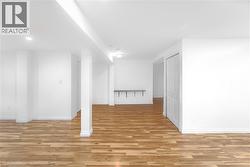 Below grade area with light wood-style floors and recessed lighting - 