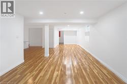 Below grade area with light wood-type flooring and recessed lighting - 